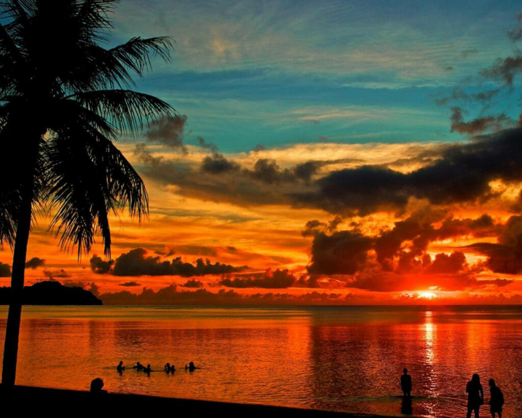 Breathtaking Sunset Scene at Guam's Beachfront, Captivating Spectators Wallpaper