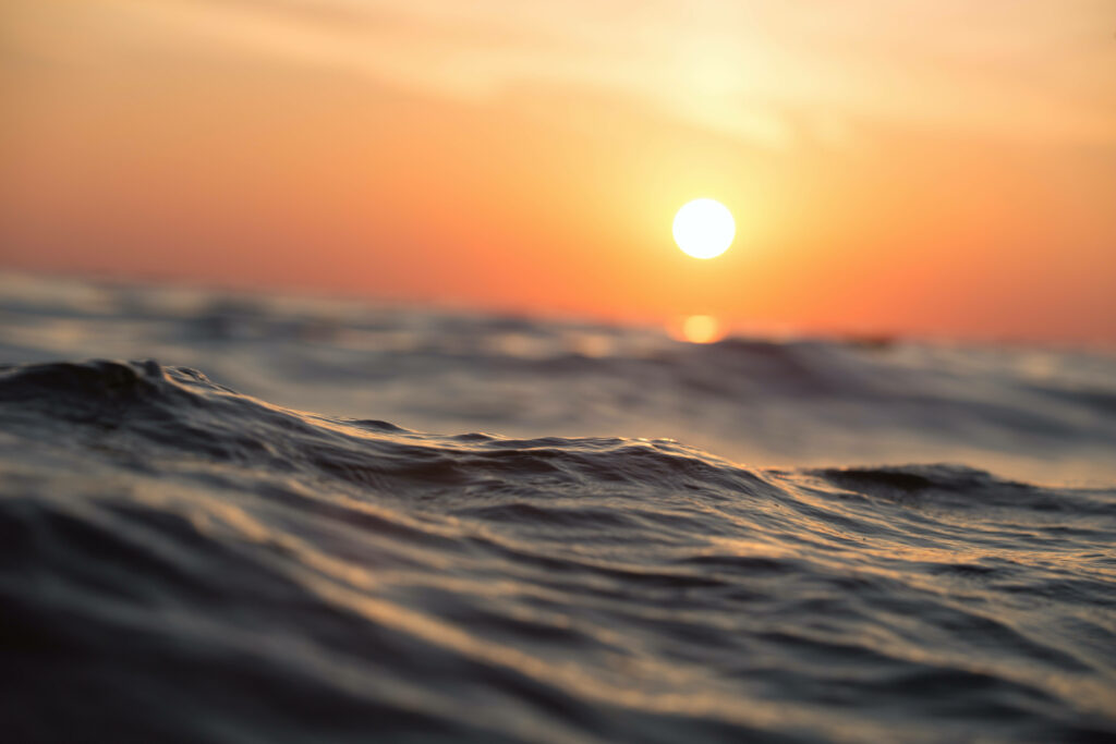 Captivating Coastal Calm: Vibrant Sunset and Majestic Blue Wave Screensaver Wallpaper