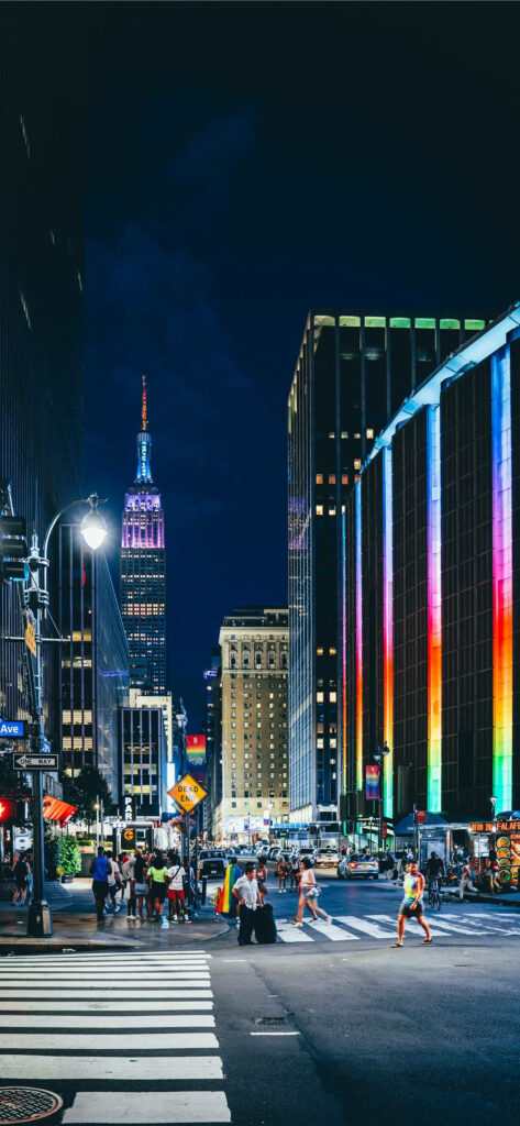 Vibrant Cityscape: Iconic Empire State Building amid Colorful High-Rise Buildings in New York City - Captivating Background Image Wallpaper