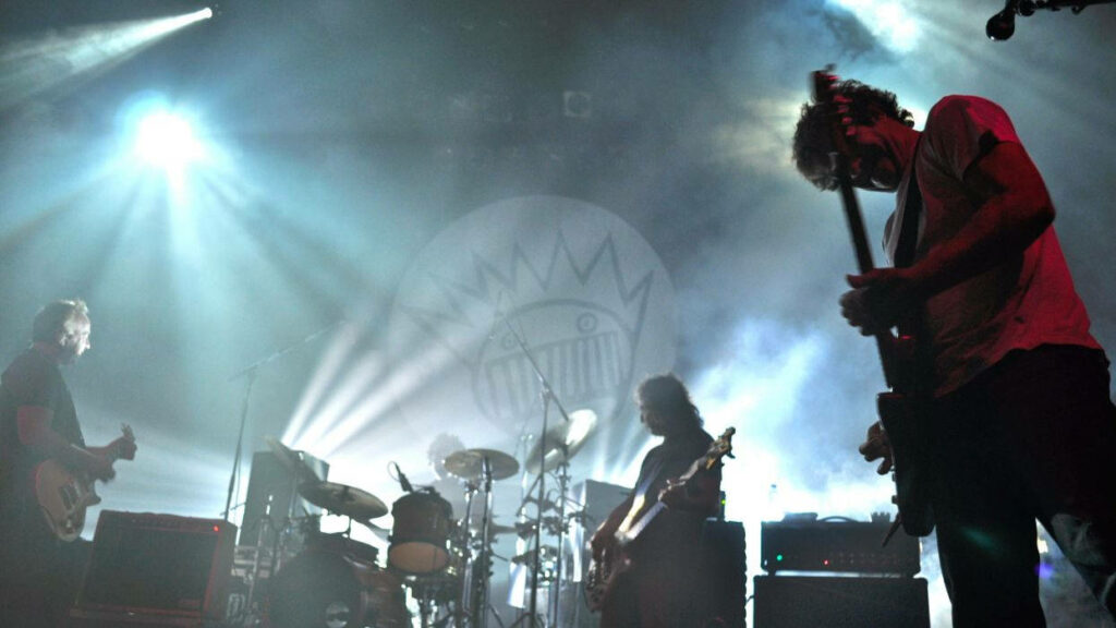 Foggy Melodies: Captivating Lo Fi Photograph of Musicians Jamming on Stage with Smoke Effects Wallpaper