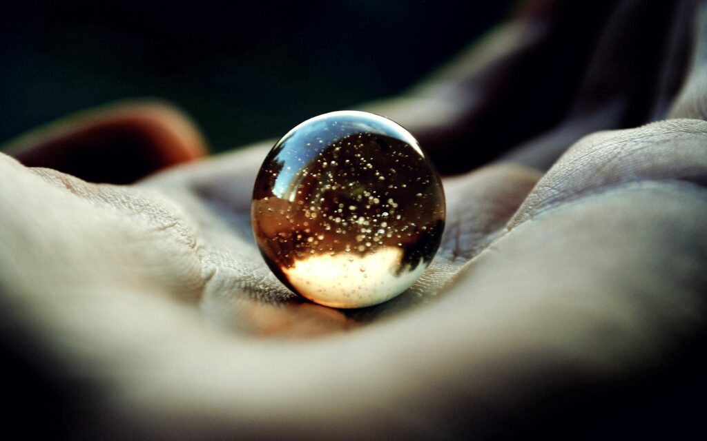 “Stunning Wallpaper: Close-Up of Hand Holding Reflective Glass Ball”