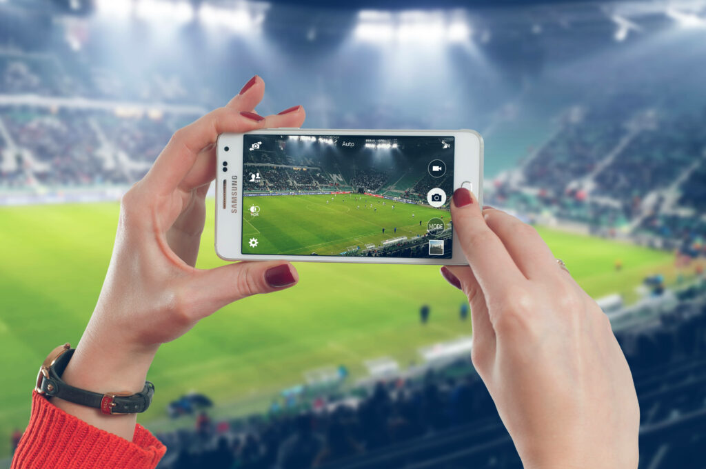 Smartphone Photo of Soccer Game in Spectator-Filled Stadium Wallpaper
