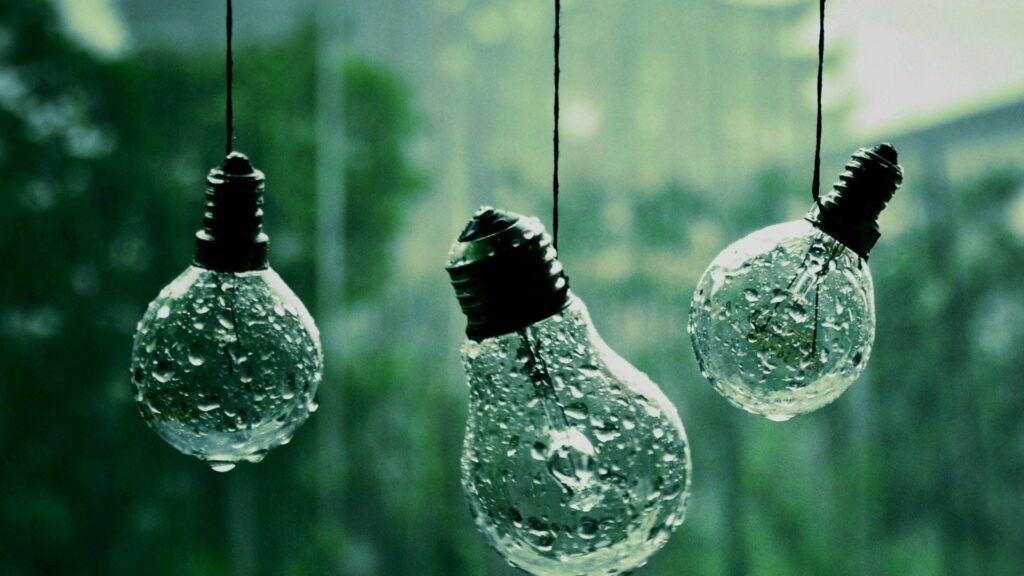 Glistening Water Droplets Amidst Blurred Glass Bulbs: A Mesmerizing HD Wallpaper