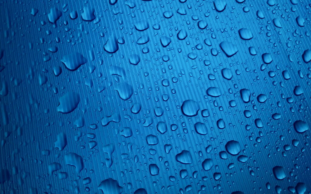 Aqua Symphony: Mesmerizing Water Drops Dance on a Blue Canvas - 4K Wallpaper