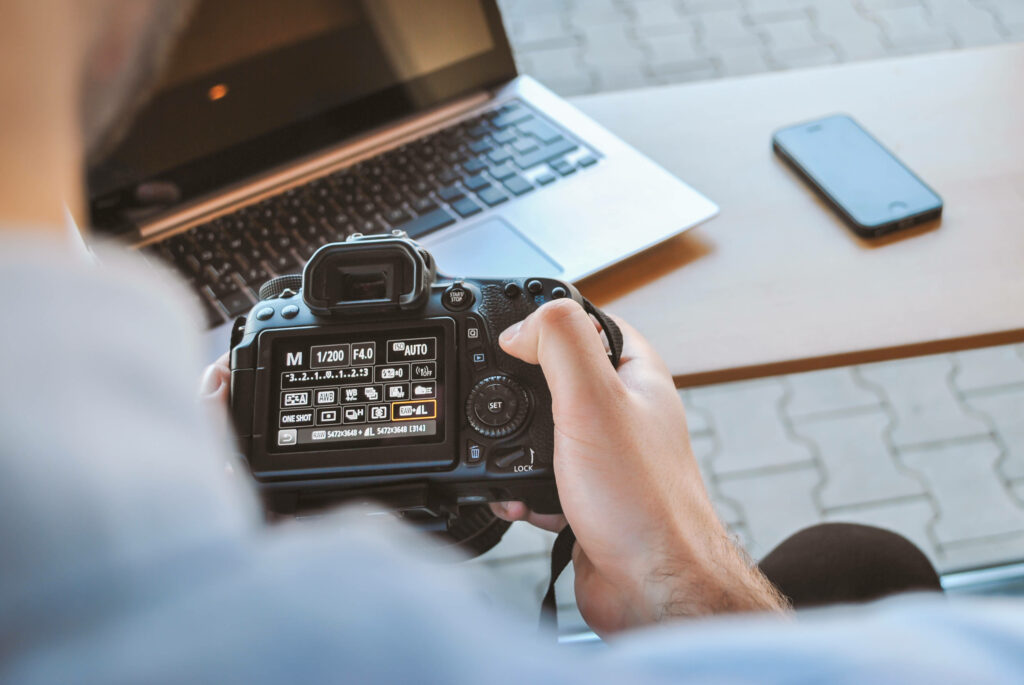 Mastering the Art of Photography: A Captivating Image of a Black DSLR Camera in the Hands of a Skilled Photographer Wallpaper