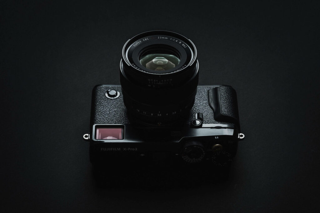 Capturing Simplicity: A Stylish Fujifilm X-Pro2 Camera Set Against a Camera-themed Backdrop Wallpaper