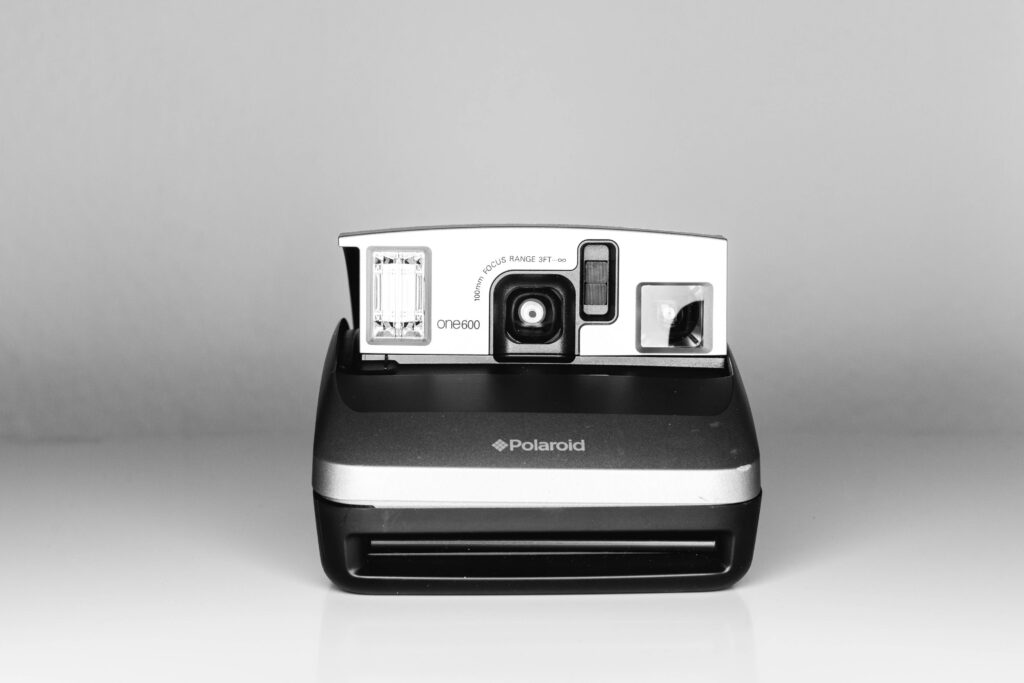 Pixelated Nostalgia: A Vintage Black Polaroid Meets Modern Webcam Lens Wallpaper