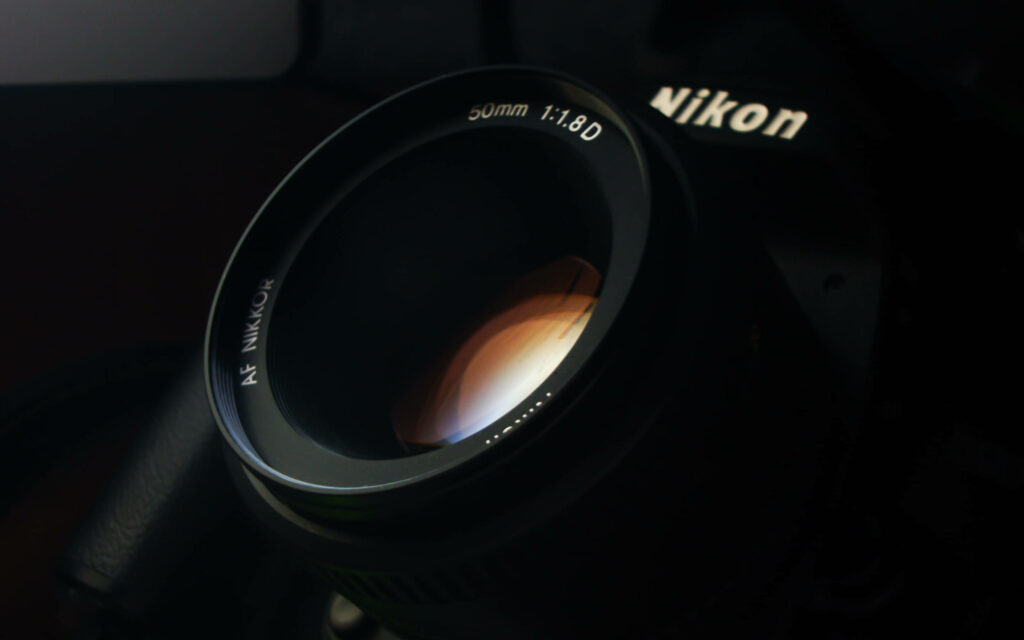 Focus on Perfection: The Nikon DSLR Camera in Striking Black Wallpaper