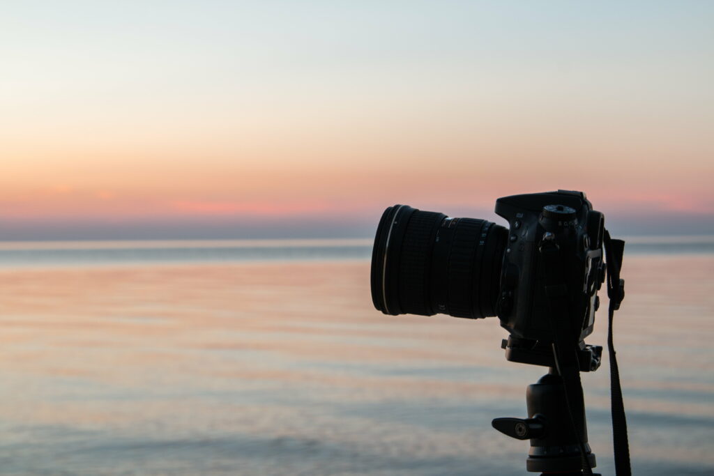Capturing Perfection: Sleek DSLR Camera poised on Tripod against Majestic 5K Wallpaper