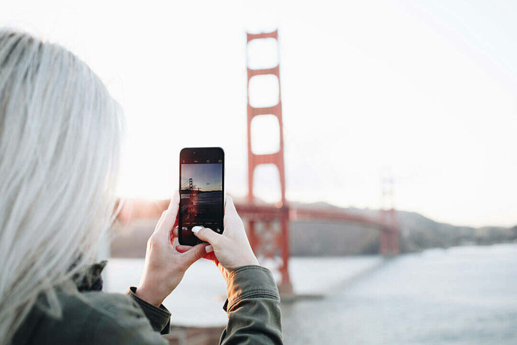 Capturing the Majestic Golden Gate Bridge on an iPhone: Photography Enthusiast with White Hair Wallpaper
