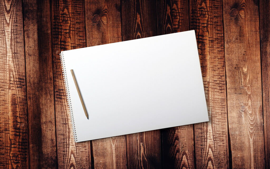 Graceful Simplicity: Captivating Macro of a Blank Notebook on a Wooden Board Wallpaper