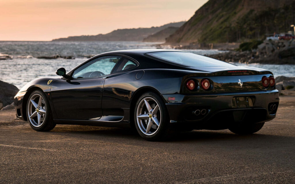 Black Ferrari's Iconic 360 Modena Near Ocean Background Wallpaper