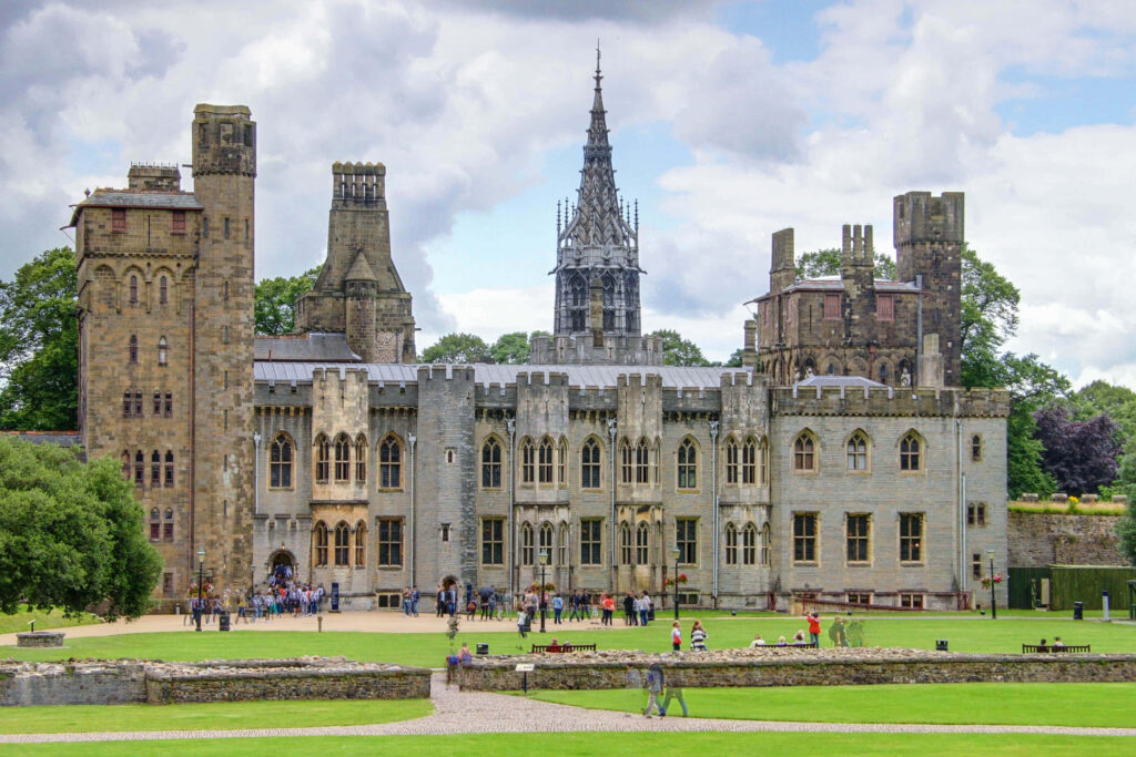 Cardiff Castle front view with medieval turrets spire lush greenery and dramatic sky wallpaper