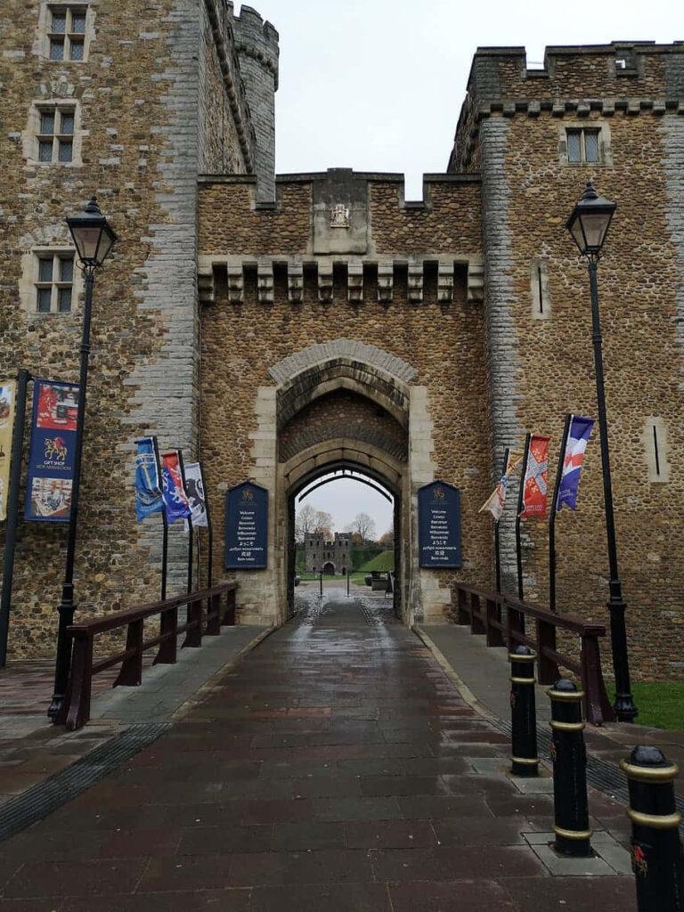 Cardiff Castle stone entrance with tall towers vibrant flags and overcast sky medieval fortress Wallpaper