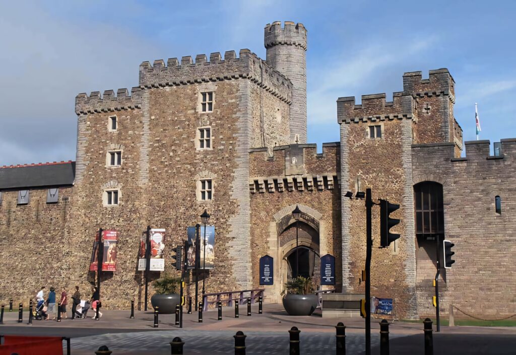 South Gate of Cardiff Castle with stone walls battlements and rounded tower under clear sky wallpaper