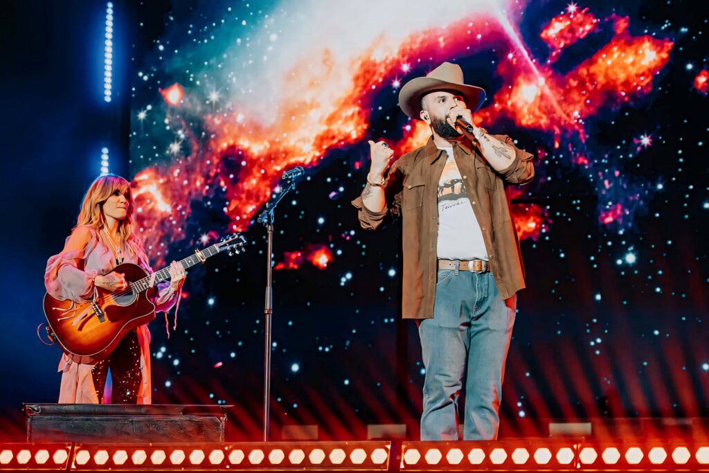 Carin León live concert with vibrant cosmic galaxy backdrop and dynamic space-themed lighting Wallpaper