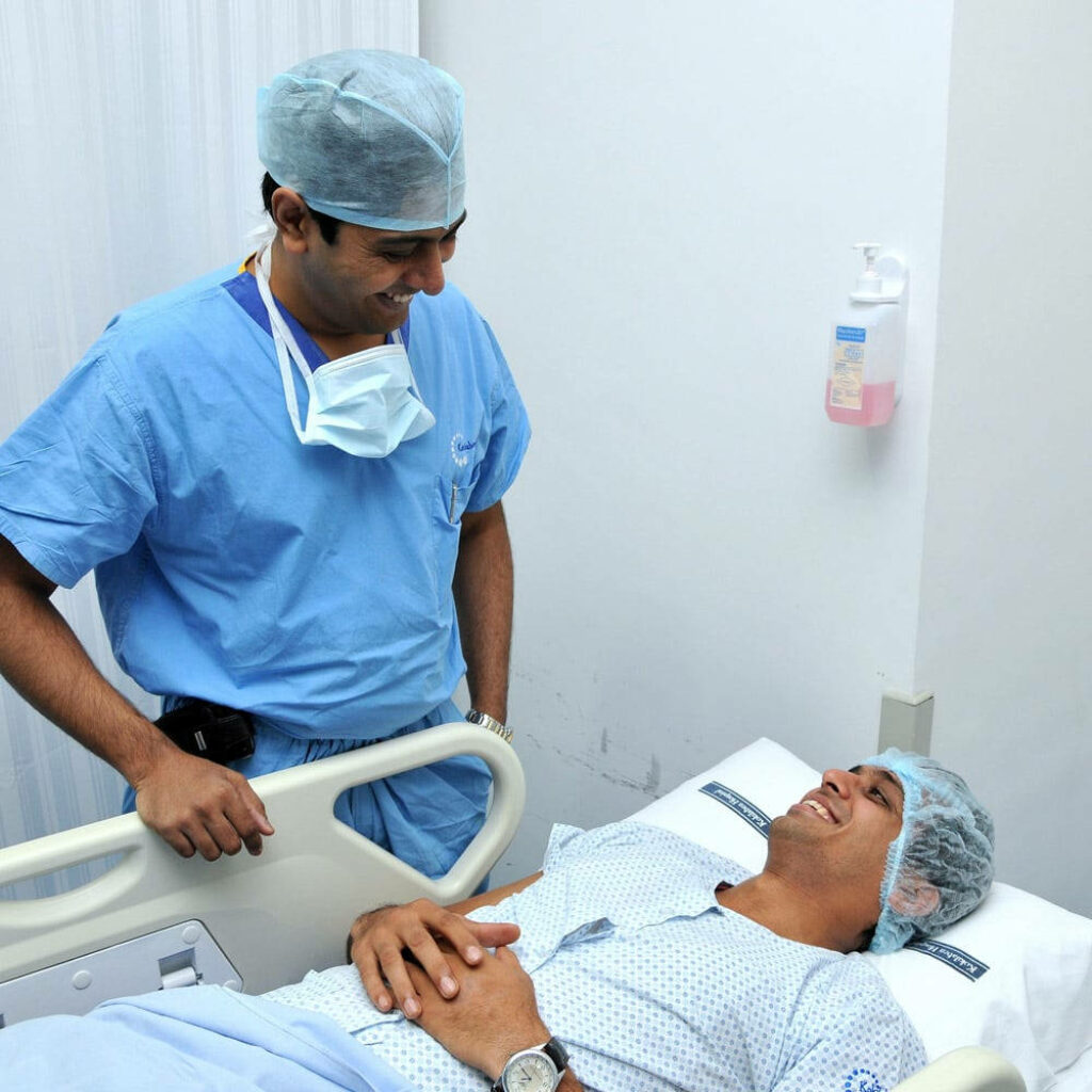 Caring doctor in blue scrubs sharing warm smile with patient in hospital bed healthcare trust Wallpaper