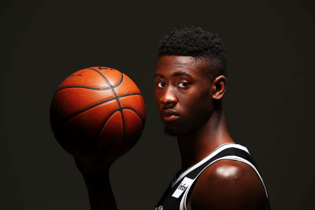 Caris LeVert Brooklyn Nets portrait holding basketball dramatic lighting minimalist background Wallpaper