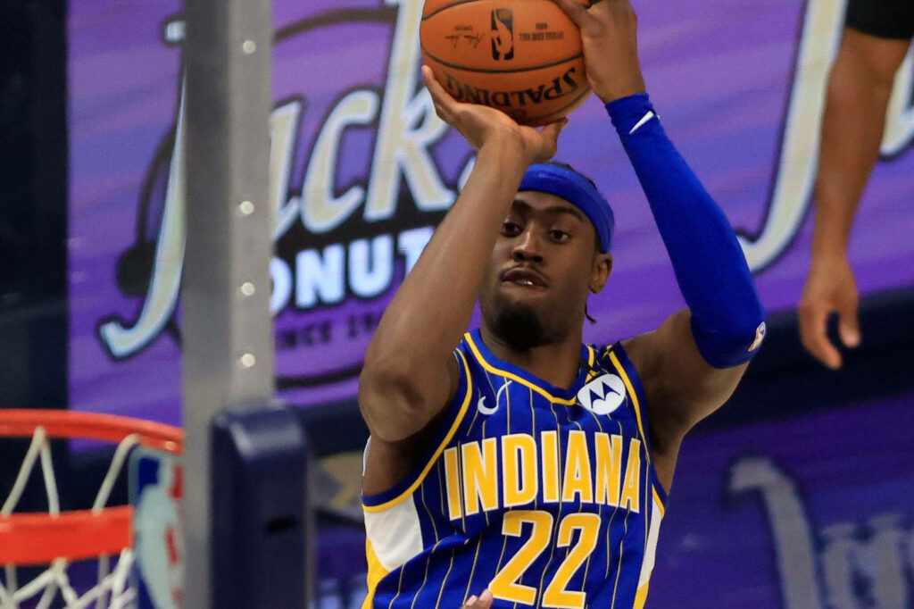 Caris LeVert mid-jump shot close-up in Indiana Pacers blue and yellow uniform vibrant arena background Wallpaper