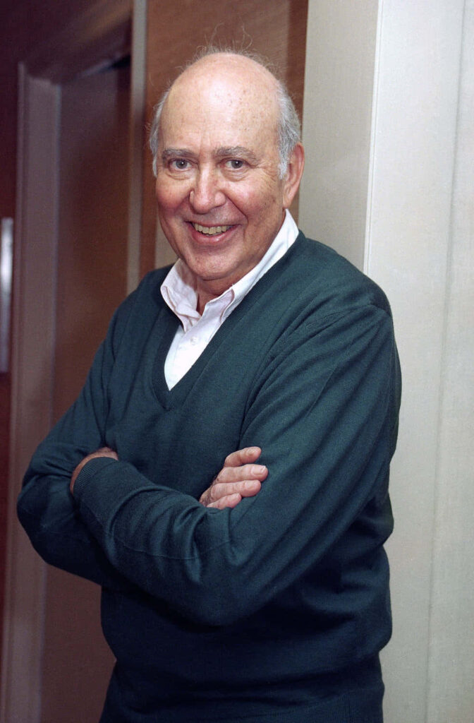 Carl Reiner portrait indoors arms crossed dark green sweater warm lighting classic style wallpaper
