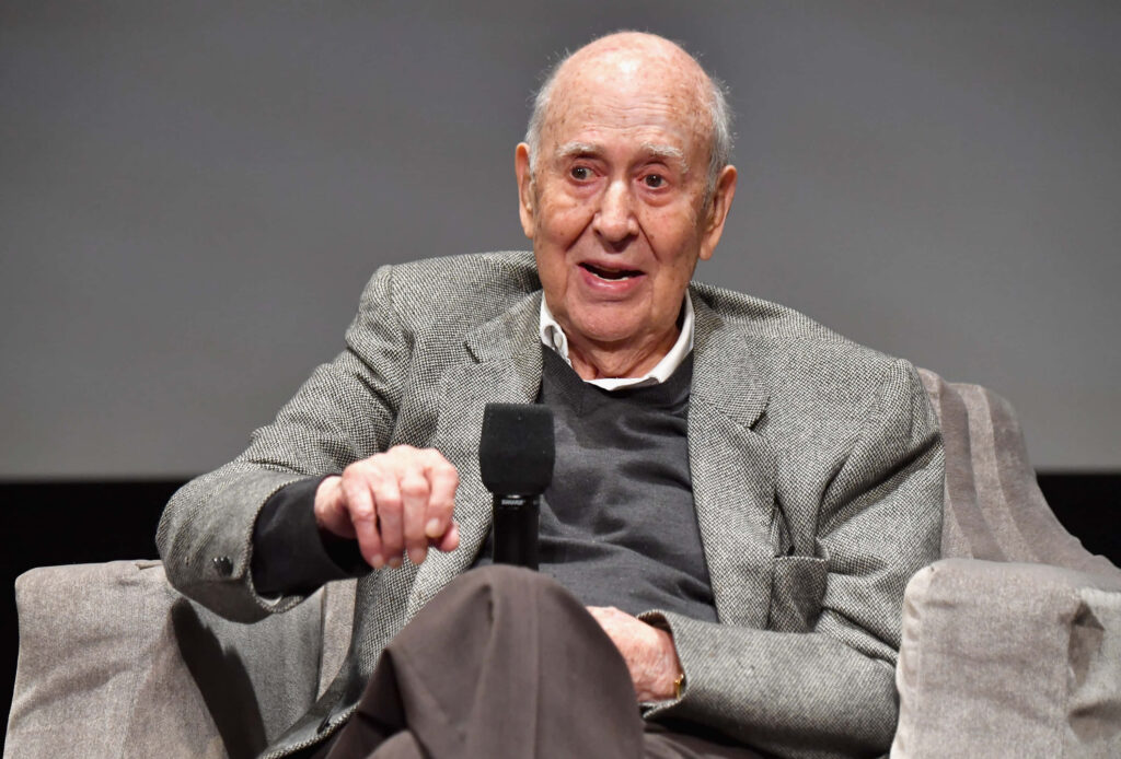 Carl Reiner speaking with microphone wearing gray blazer dark sweater candid portrait wallpaper