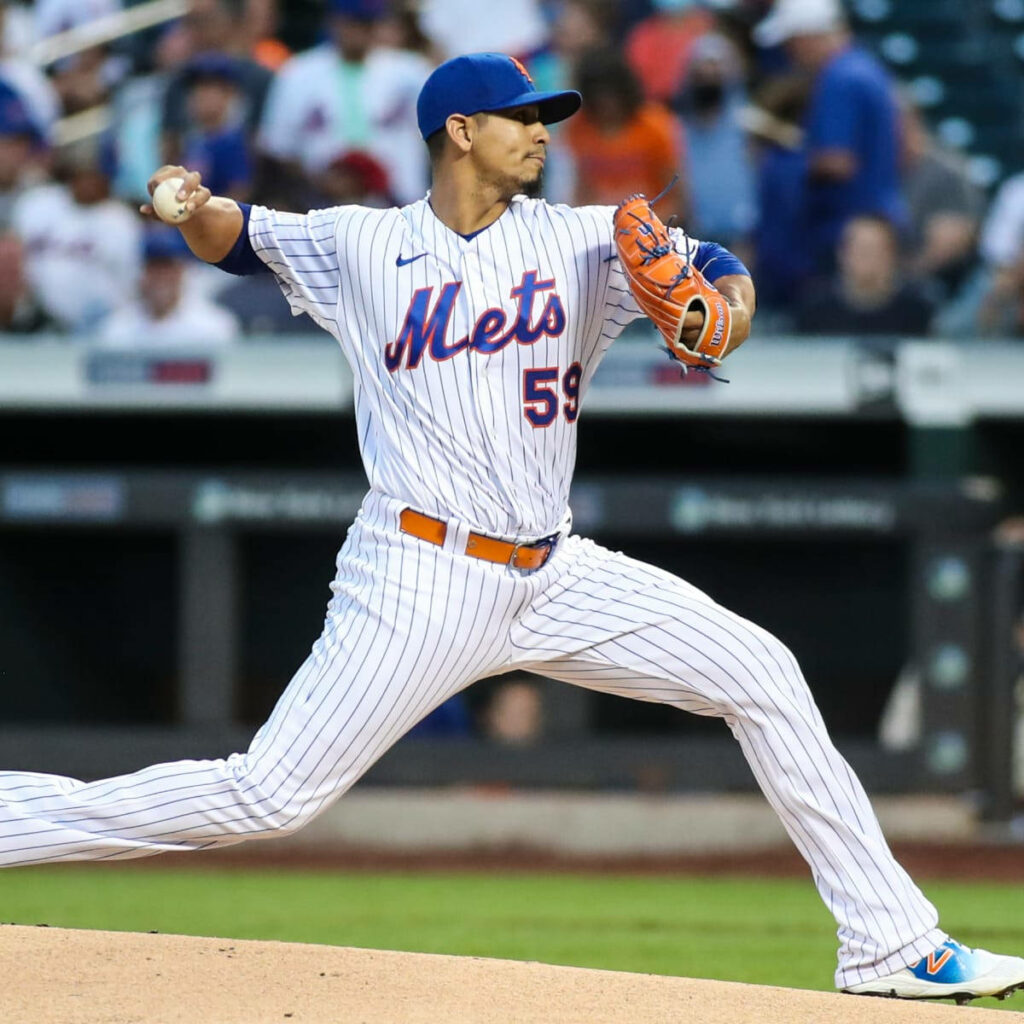 Carlos Carrasco pitching in Mets white pinstripe uniform dynamic baseball stadium wallpaper