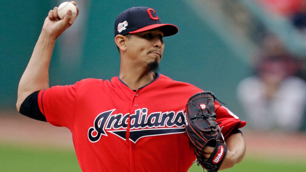 Carlos Carrasco pitching in red Cleveland Indians jersey with vibrant baseball stadium background Wallpaper