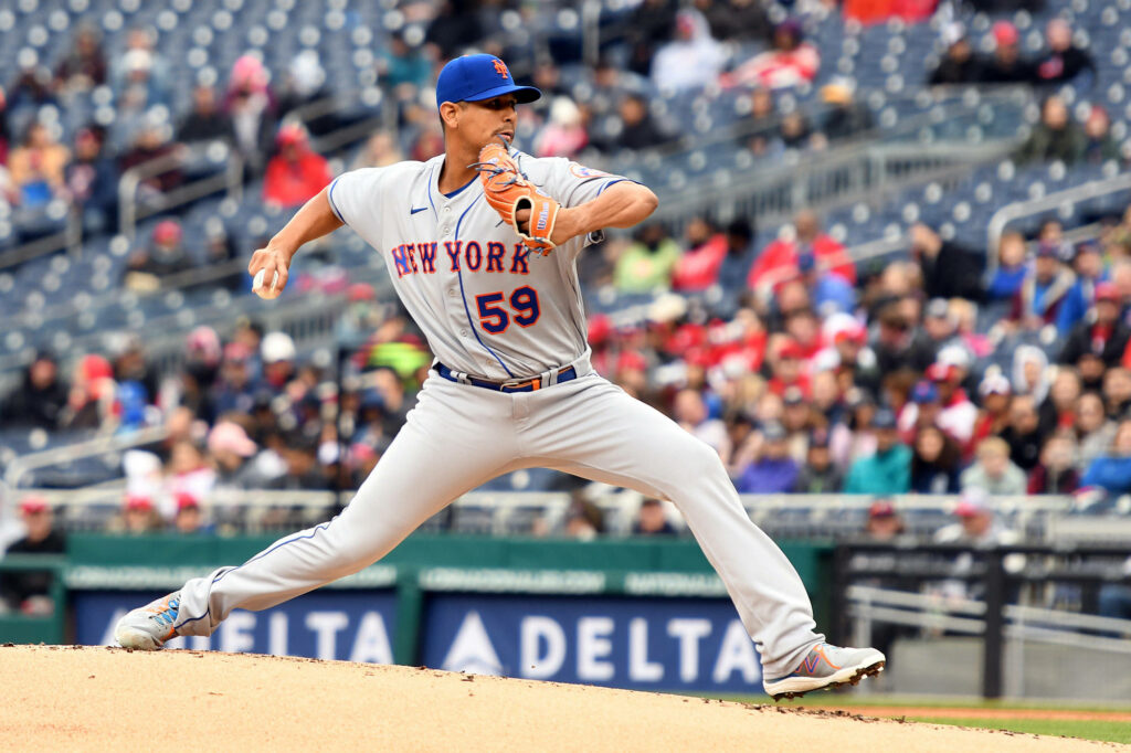 Carlos Carrasco pitching for New York Mets in sharp focus with blurred crowd background action Wallpaper