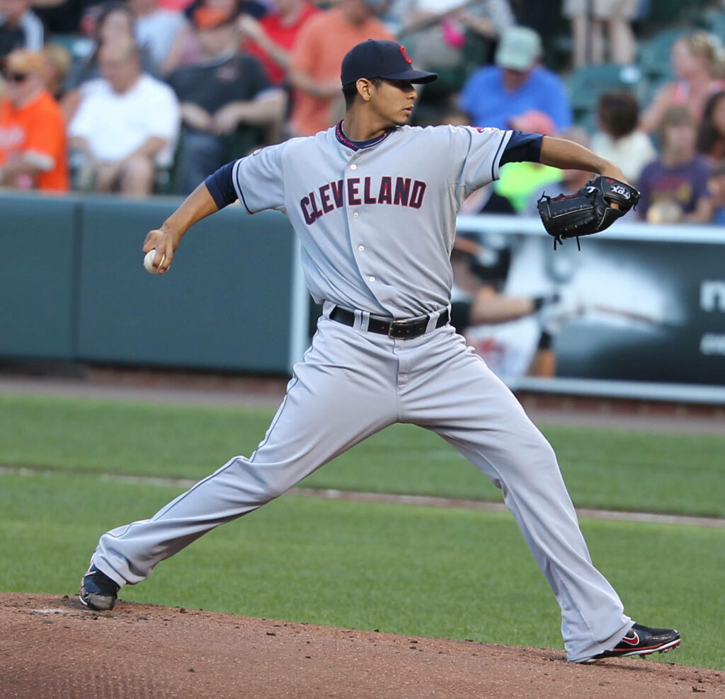 Carlos Carrasco pitching for Cleveland White Sox in gray away uniform on stadium mound Wallpaper