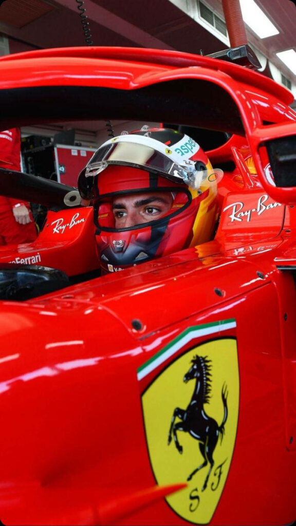 Carlos Sainz Jr in red Ferrari helmet ready for Azerbaijan Grand Prix with prancing horse logo Wallpaper