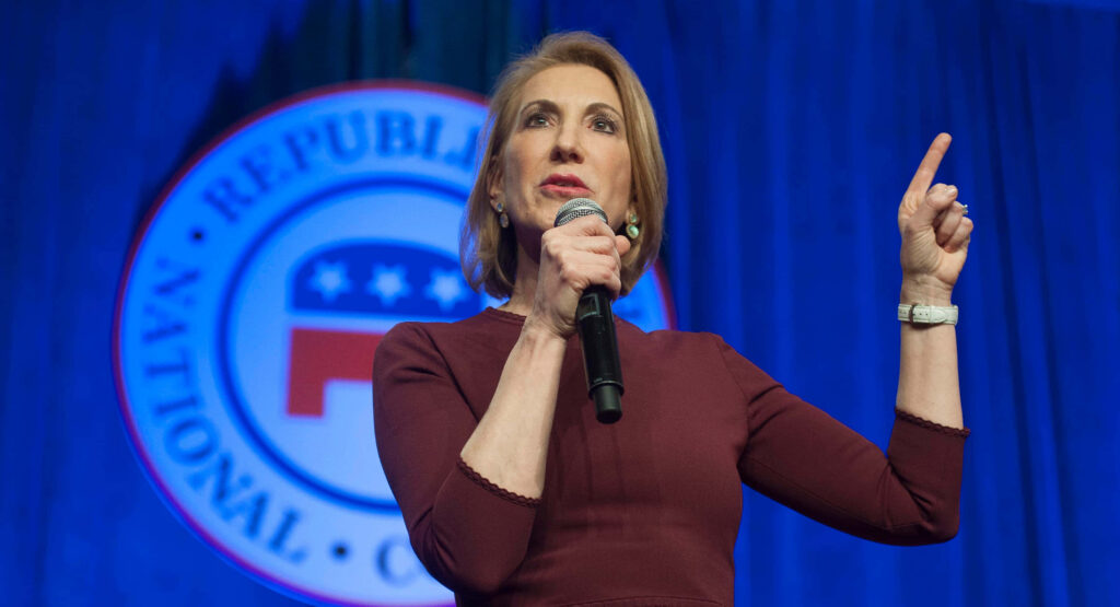Carly Fiorina speaking confidently at Republican National Committee event with RNC logo backdrop Wallpaper