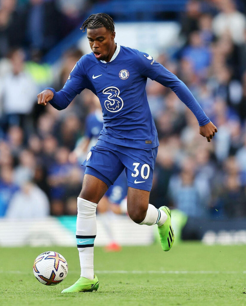 Carney Chukwuemeka in Chelsea blue kit controlling ball focused intense action on football pitch Wallpaper