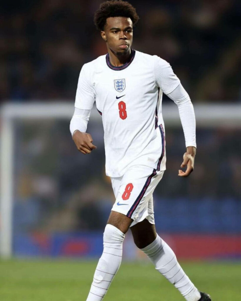 Carney Chukwuemeka focused on pitch wearing England number 8 kit vibrant white red colors wallpaper