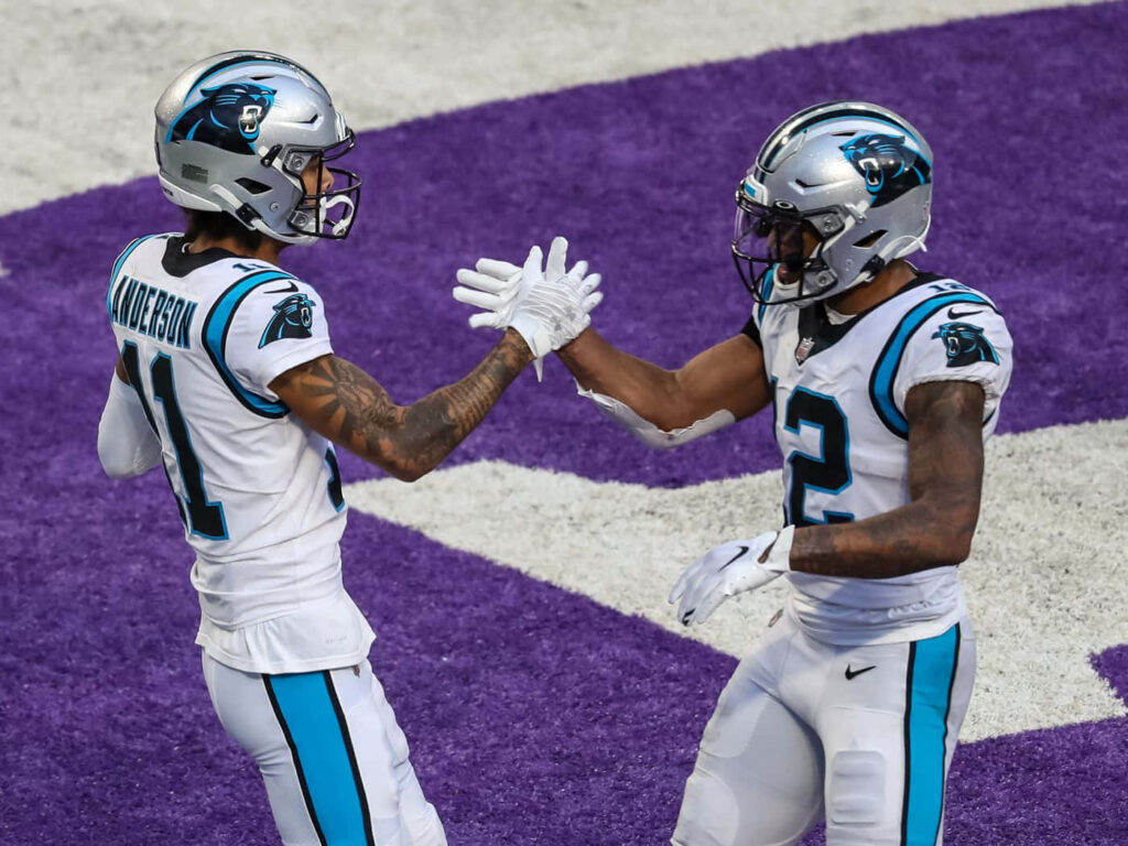 Carolina Panthers DJ Moore and Robby Anderson celebrating in white blue uniforms on purple background Wallpaper