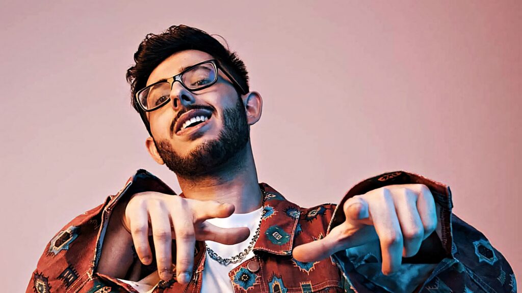 CarryMinati high-resolution wallpaper vibrant pink background confident pose stylish jacket