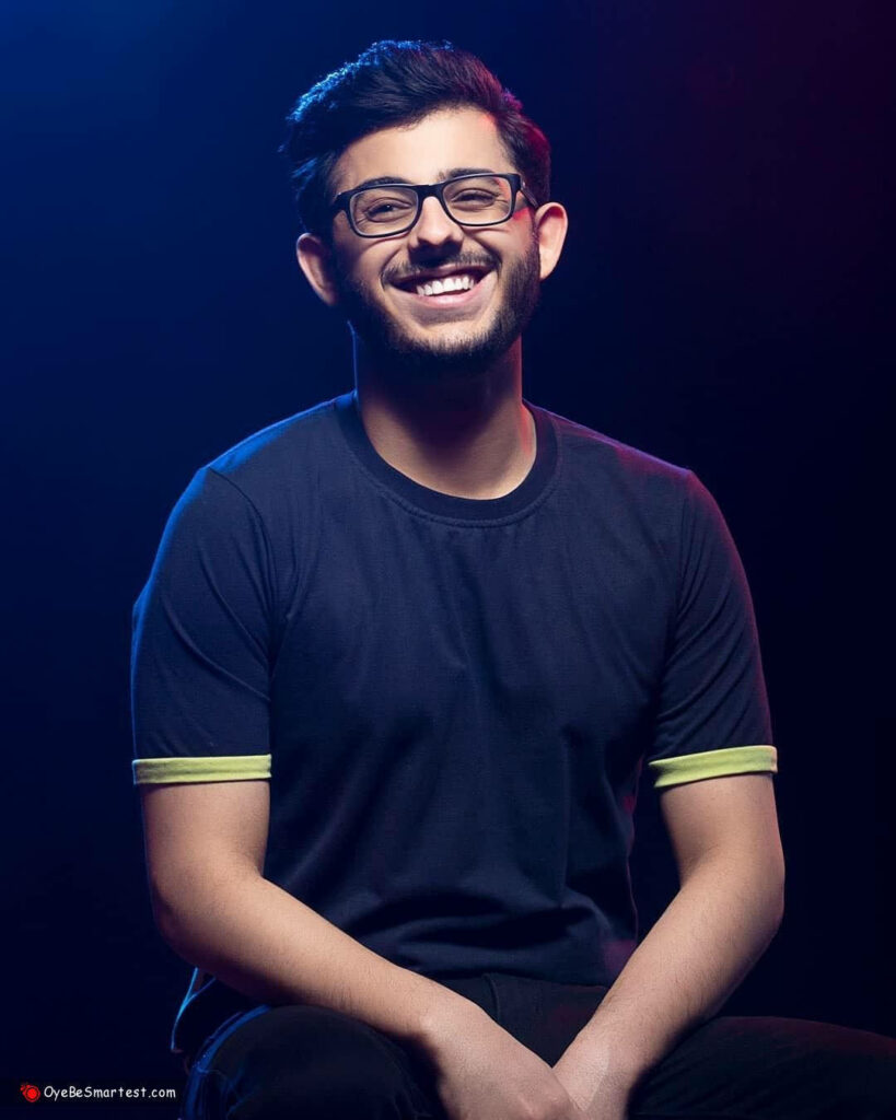 CarryMinati vibrant portrait wallpaper smiling confidently dark background colorful lighting