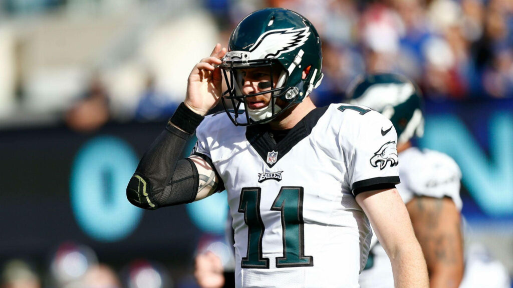 Carson Wentz in white Philadelphia Eagles uniform number 11 mid-game on vibrant football field Wallpaper