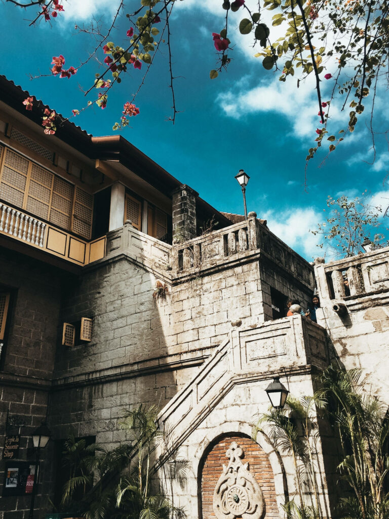 Captivating Museum in Manila's Historic Intramuros: Casa Manila, Beneath Clear Skies and Blooming Flowers Wallpaper