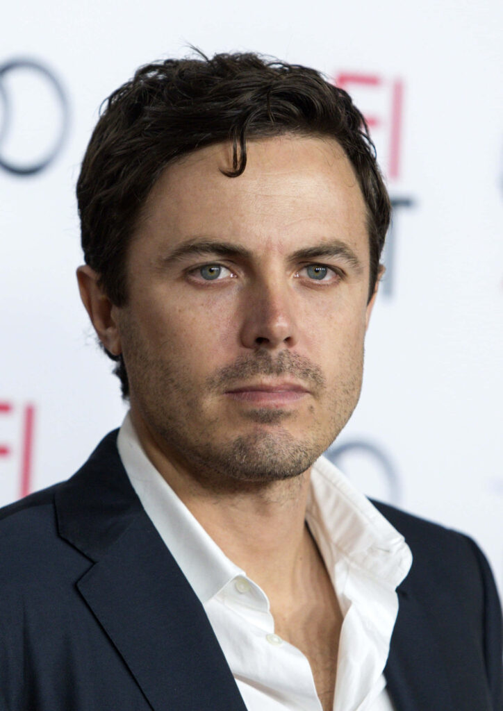Casey Affleck close-up portrait in sharp blue suit with soft blurred background wallpaper