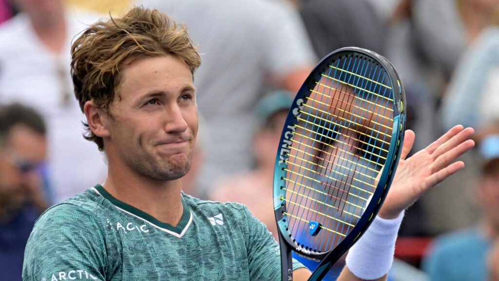 Casper Ruud clapping racket on tennis court showing determination and sportsmanship in action Wallpaper