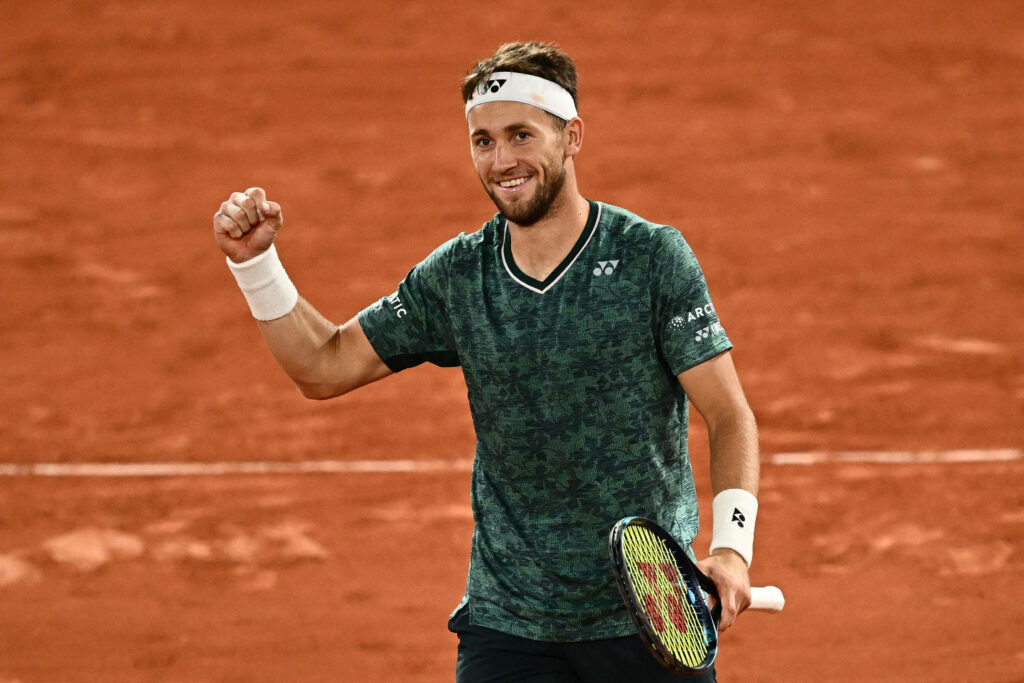 Casper Ruud celebrates victory on clay court wearing green shirt with dynamic tennis energy Wallpaper