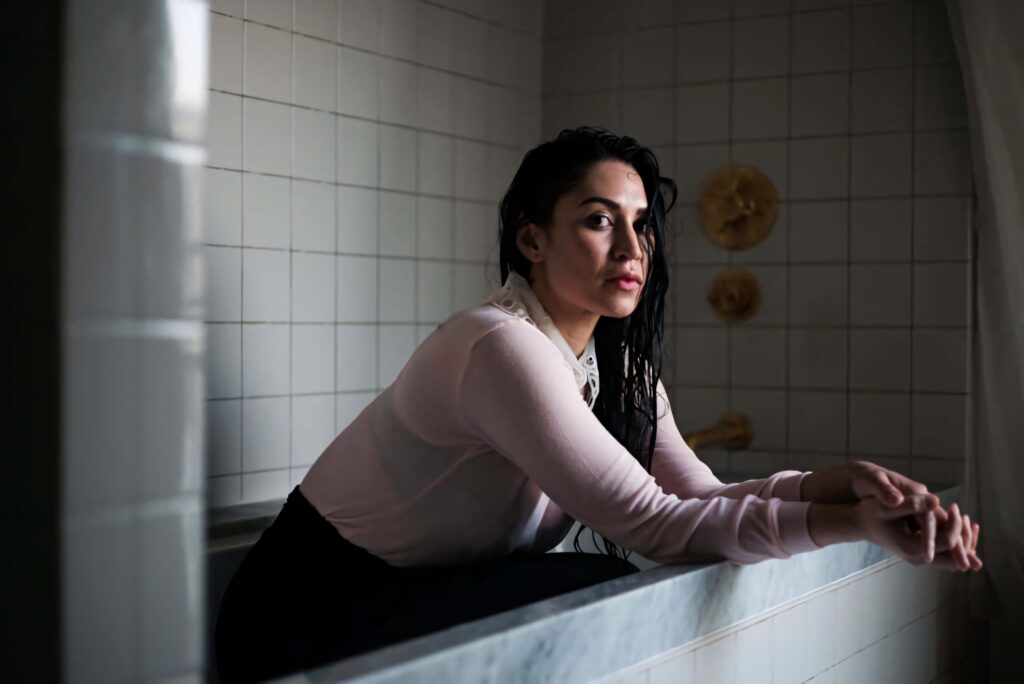 Cassie Steele leaning on tiled window sill with wet hair in soft natural light contemplative pose Wallpaper