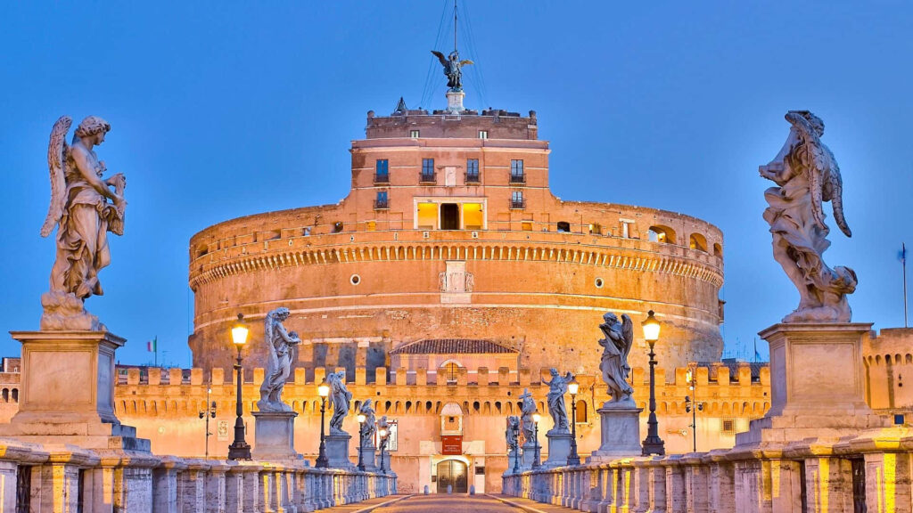 Castel Sant Angelo Rome at golden hour with statues and lampposts against blue sky wallpaper