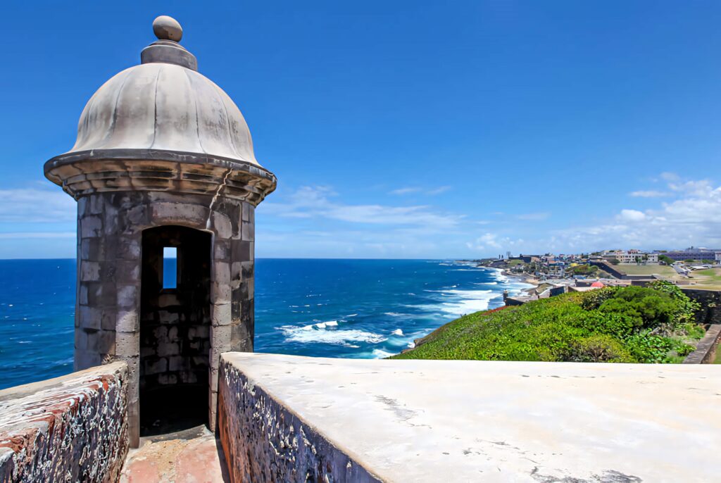 Sentry box of Castillo San Felipe del Morro with ocean and coastline in sunny San Juan Puerto Rico Wallpaper