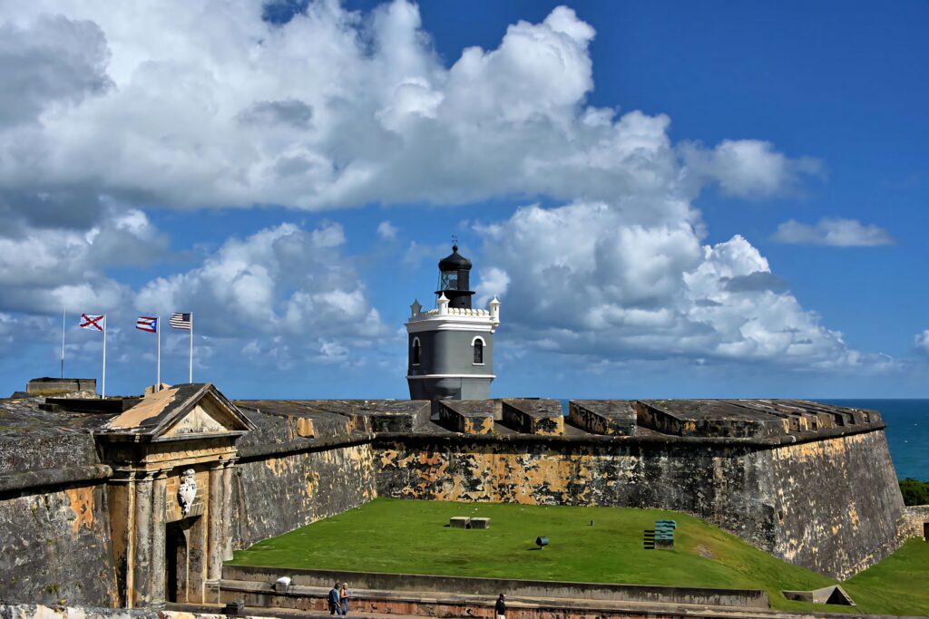 Back view of Castillo San Felipe del Morro fortress with black white lighthouse and blue sky Wallpaper