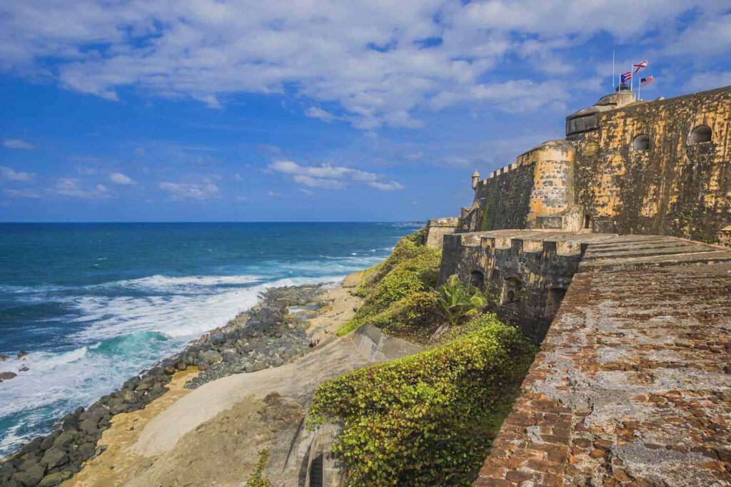 Historic Castillo San Felipe del Morro stone walls overlooking vibrant blue Atlantic Ocean sky Wallpaper