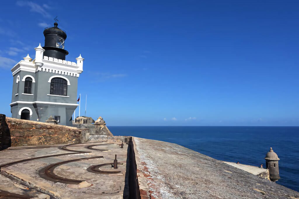 Castillo San Felipe del Morro Lighthouse under blue sky with Caribbean Sea coastal stonework wallpaper