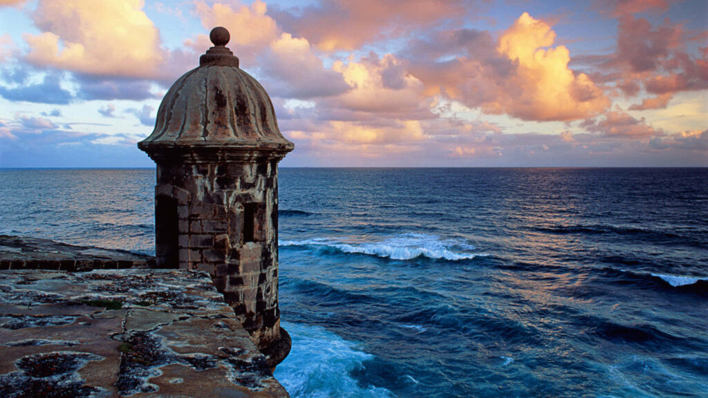 Historic Castillo San Felipe del Morro sentry box overlooking vibrant blue Atlantic Ocean coastal view Wallpaper
