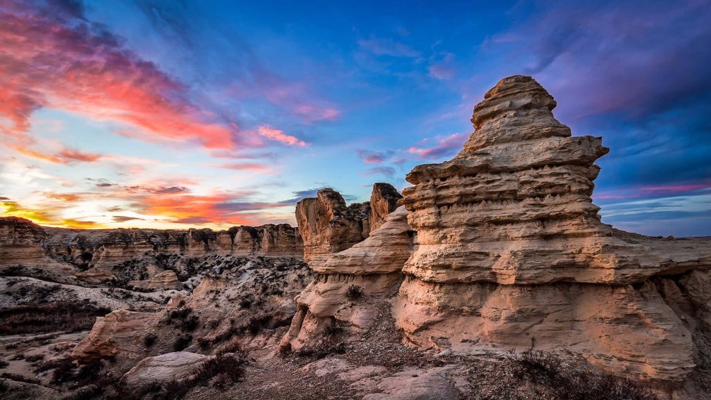 Castle Rock Kansas chalk formations at sunset vibrant orange blue sky Midwest badlands wallpaper