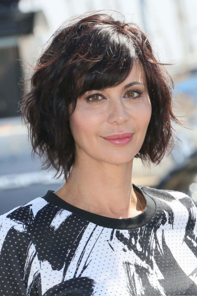Close-up portrait of Catherine Bell with wavy dark hair and modern monochrome outfit wallpaper